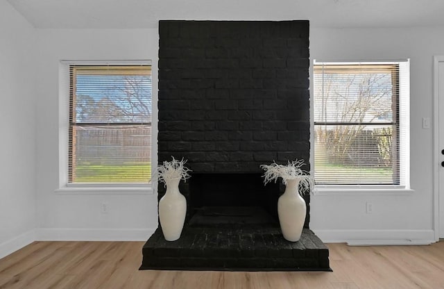 interior space with hardwood / wood-style flooring and a brick fireplace