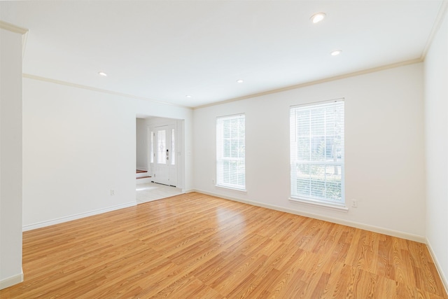 empty room with crown molding and light wood-type flooring