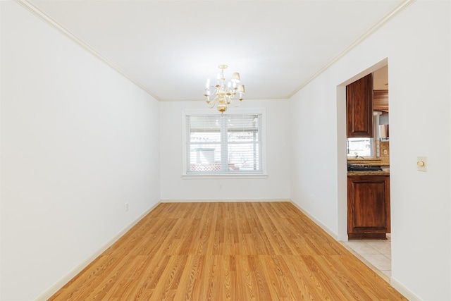 unfurnished dining area with an inviting chandelier, ornamental molding, and light hardwood / wood-style flooring