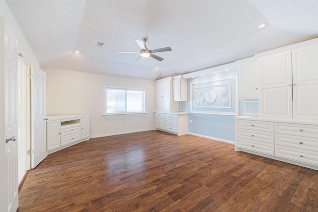 unfurnished bedroom with ceiling fan, vaulted ceiling, dark wood-type flooring, and a textured ceiling