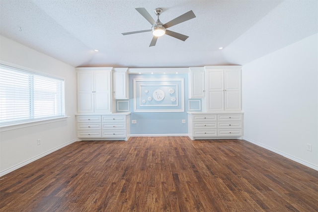 unfurnished bedroom with ceiling fan, dark wood-type flooring, and lofted ceiling