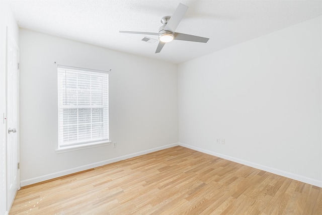 spare room featuring ceiling fan, light hardwood / wood-style flooring, and a healthy amount of sunlight