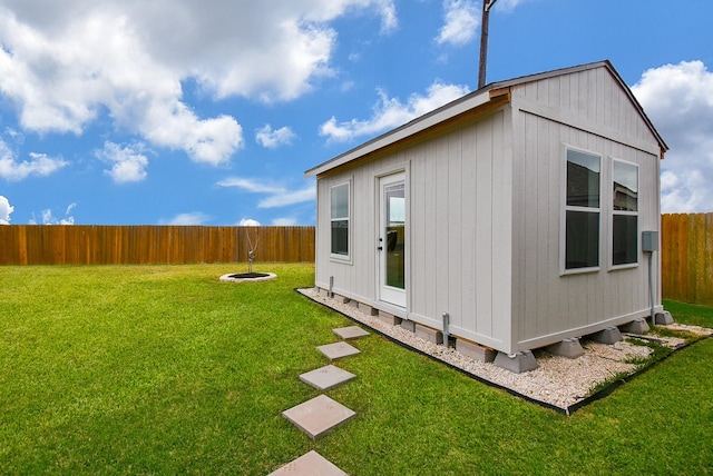 view of side of property featuring an outbuilding and a lawn