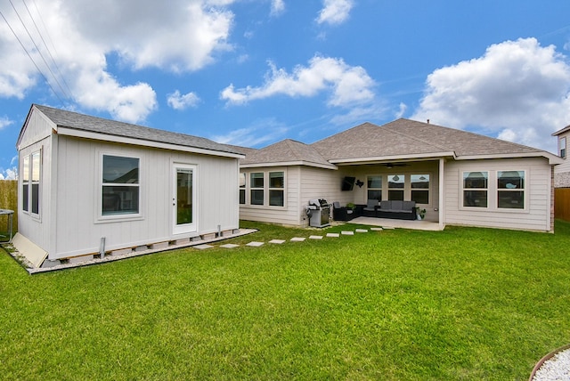 back of house with ceiling fan, an outdoor living space, a patio area, and a yard