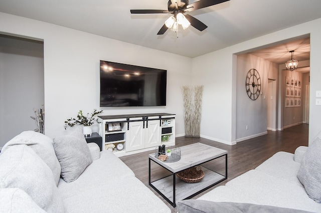 living room featuring ceiling fan with notable chandelier and dark hardwood / wood-style flooring