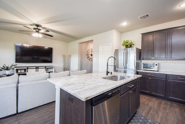 kitchen featuring stainless steel appliances, sink, dark hardwood / wood-style floors, a kitchen island with sink, and dark brown cabinets