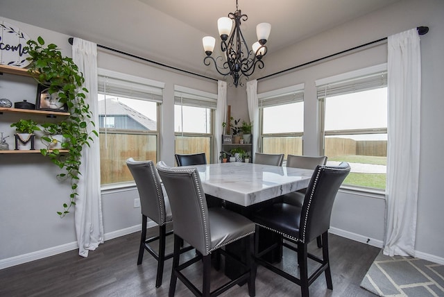 dining area with plenty of natural light, dark hardwood / wood-style floors, and a notable chandelier