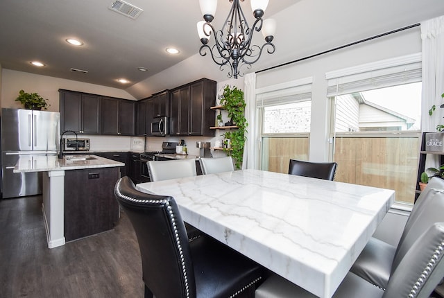 dining room with sink, dark hardwood / wood-style floors, lofted ceiling, and a chandelier