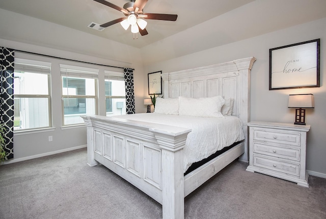 carpeted bedroom with ceiling fan and multiple windows