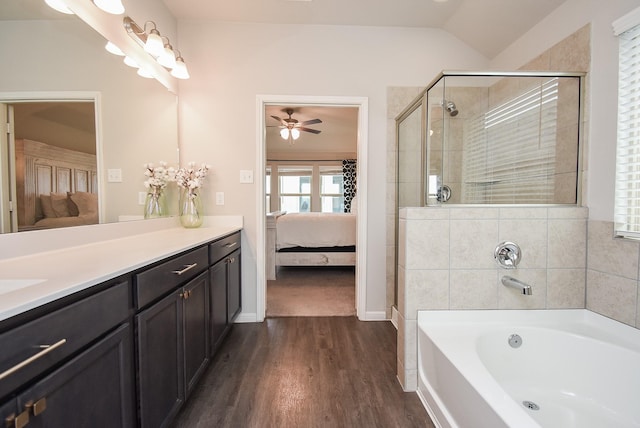 bathroom featuring vanity, ceiling fan, vaulted ceiling, hardwood / wood-style flooring, and separate shower and tub