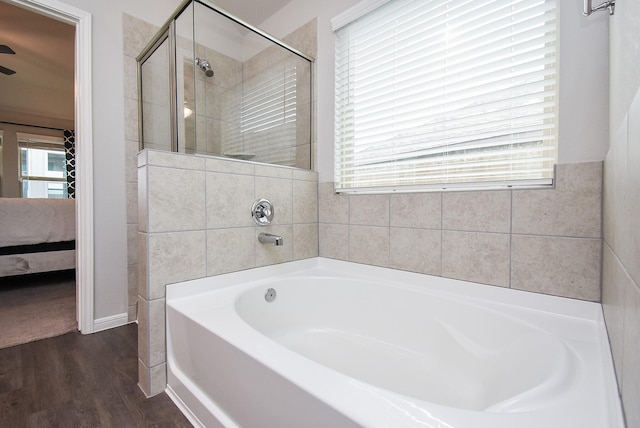 bathroom with independent shower and bath and hardwood / wood-style flooring