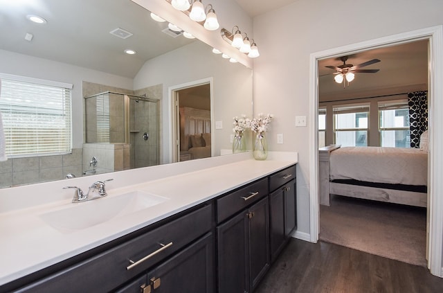 bathroom with ceiling fan, lofted ceiling, wood-type flooring, walk in shower, and vanity