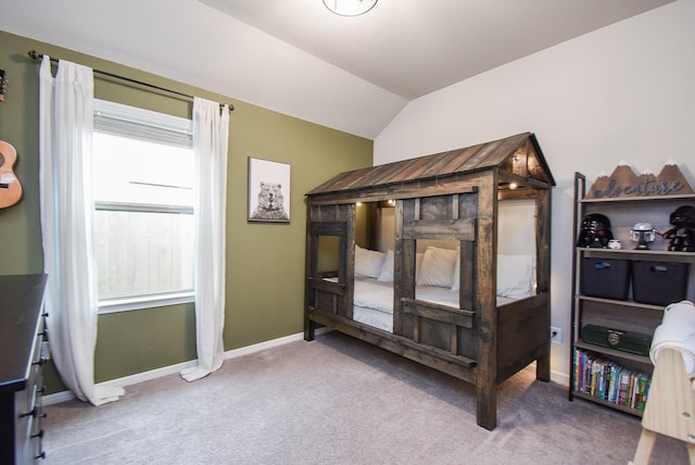 carpeted bedroom with vaulted ceiling and multiple windows