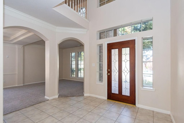 tiled foyer featuring ornamental molding and a healthy amount of sunlight