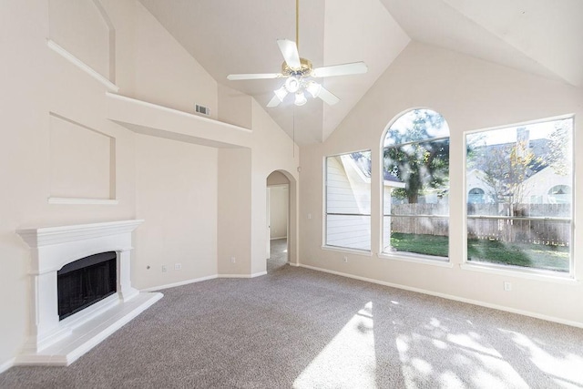 unfurnished living room featuring carpet floors, high vaulted ceiling, ceiling fan, and a healthy amount of sunlight