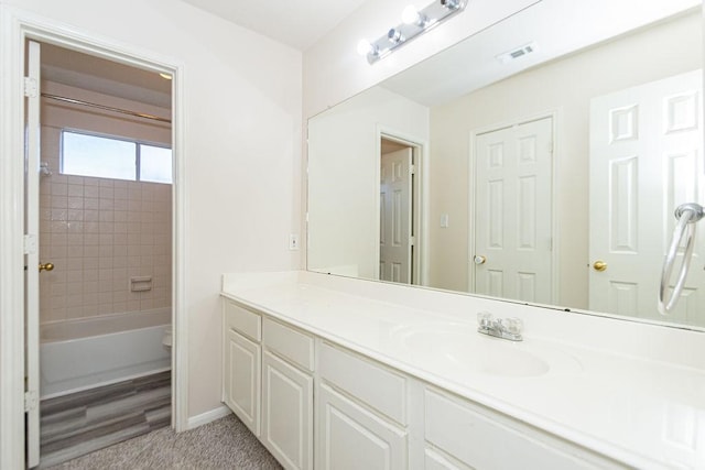 bathroom featuring tiled shower / bath combo and vanity