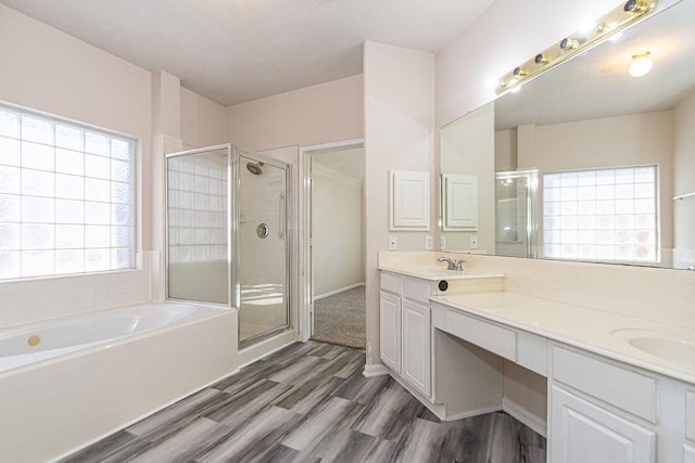 bathroom featuring vanity, hardwood / wood-style flooring, and plus walk in shower