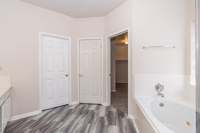 bathroom featuring a tub, hardwood / wood-style floors, and vanity