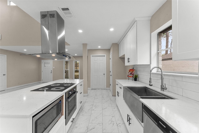 kitchen featuring light stone countertops, white cabinetry, island exhaust hood, stainless steel appliances, and backsplash