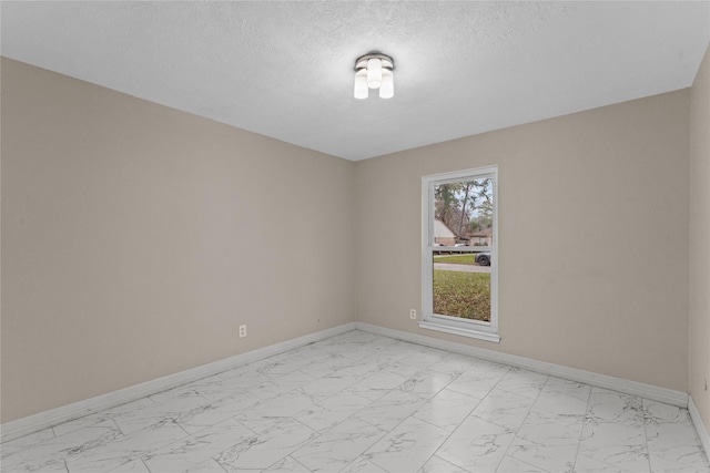 unfurnished room featuring a textured ceiling