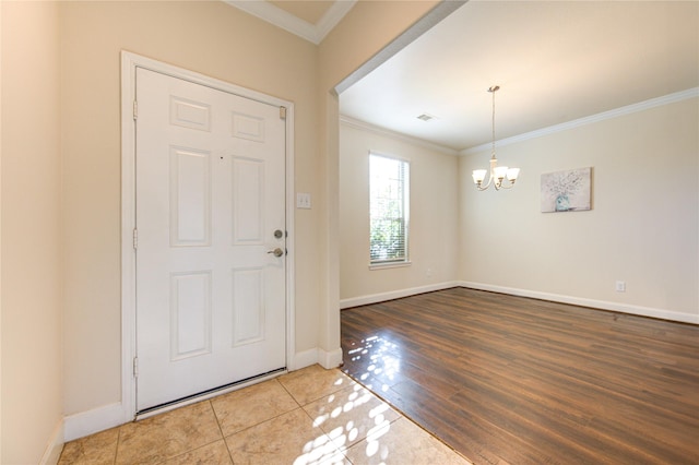 foyer featuring tile patterned floors, an inviting chandelier, and ornamental molding