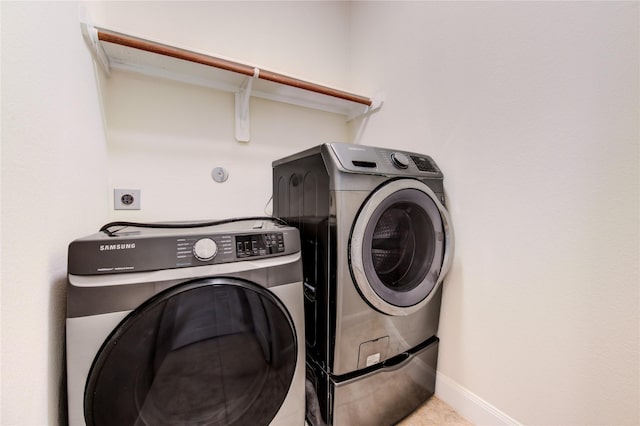 laundry room featuring light tile patterned flooring and washing machine and clothes dryer