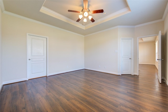 spare room with ceiling fan, a tray ceiling, dark hardwood / wood-style flooring, and crown molding