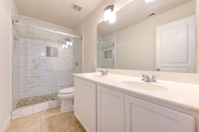 bathroom with toilet, vanity, tile patterned flooring, and a shower with door