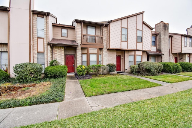 townhome / multi-family property featuring a front lawn