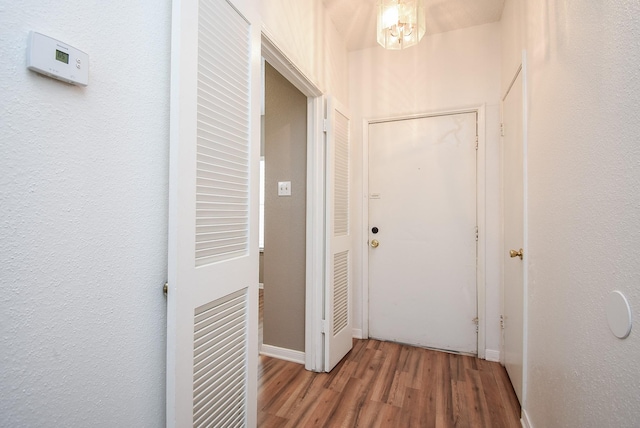 corridor with hardwood / wood-style flooring