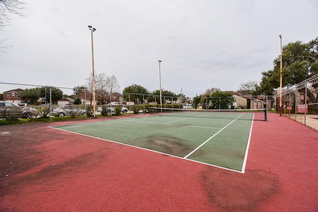 view of tennis court with basketball hoop