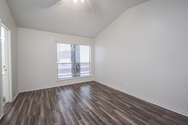 spare room with ceiling fan, vaulted ceiling, dark wood-type flooring, and a textured ceiling