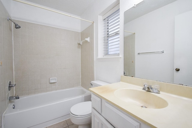 full bathroom featuring a textured ceiling, tiled shower / bath combo, tile patterned flooring, vanity, and toilet