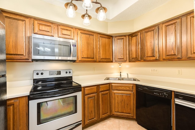 kitchen with sink, a textured ceiling, appliances with stainless steel finishes, and light tile patterned flooring