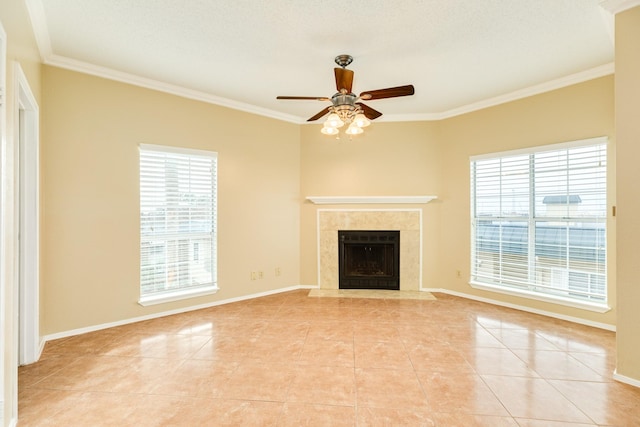 unfurnished living room featuring ceiling fan, a wealth of natural light, crown molding, and a fireplace