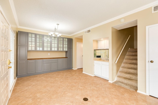 interior space featuring light tile patterned floors, a chandelier, and ornamental molding