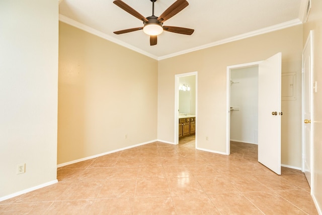 unfurnished bedroom featuring a spacious closet, ceiling fan, ensuite bathroom, and ornamental molding