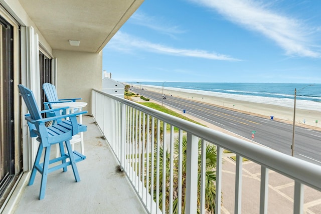 balcony with a water view and a beach view