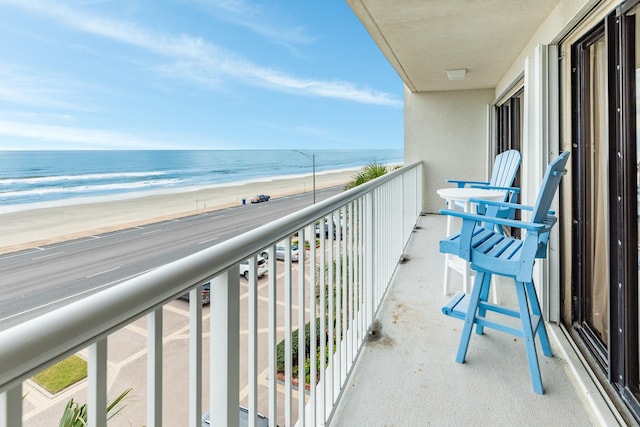 balcony featuring a beach view and a water view