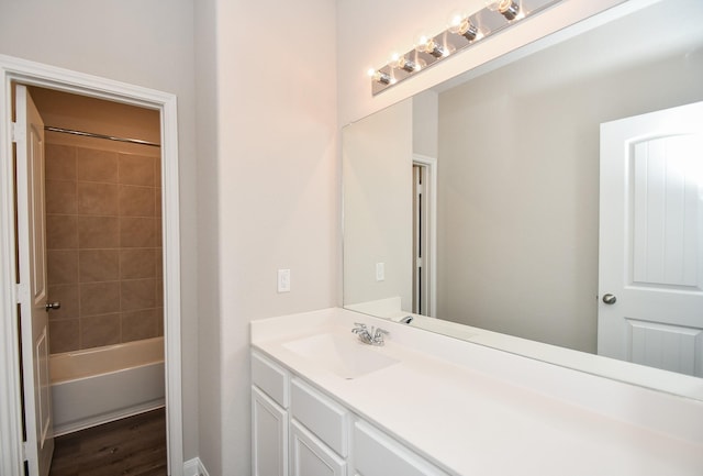 bathroom featuring wood-type flooring, vanity, and tiled shower / bath