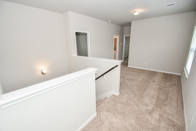 hallway featuring light colored carpet