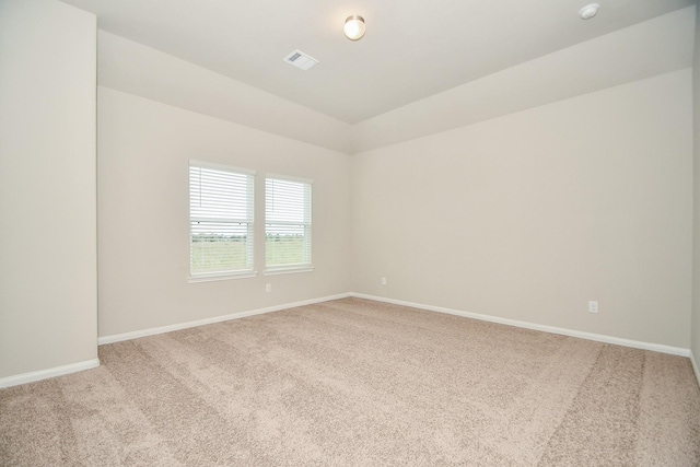 carpeted spare room featuring vaulted ceiling