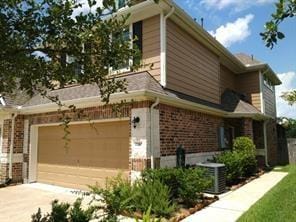 view of front of house with a garage and central air condition unit