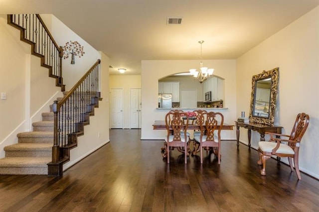 dining area featuring dark hardwood / wood-style flooring and a chandelier