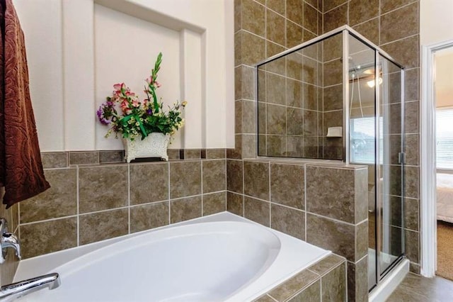 bathroom featuring shower with separate bathtub