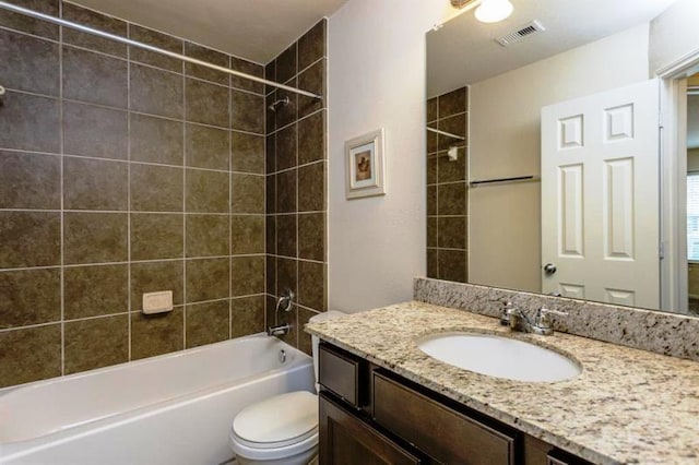 full bathroom with toilet, tiled shower / bath combo, and vanity