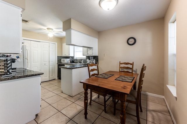 kitchen featuring light tile patterned floors, white cabinetry, ceiling fan, and white appliances