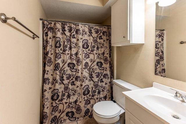 bathroom with toilet, vanity, tile patterned flooring, and a textured ceiling