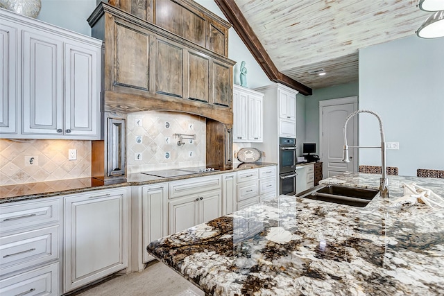 kitchen featuring white cabinets, black electric stovetop, tasteful backsplash, sink, and wooden ceiling