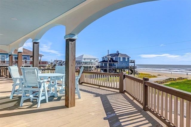 deck with a water view and a view of the beach